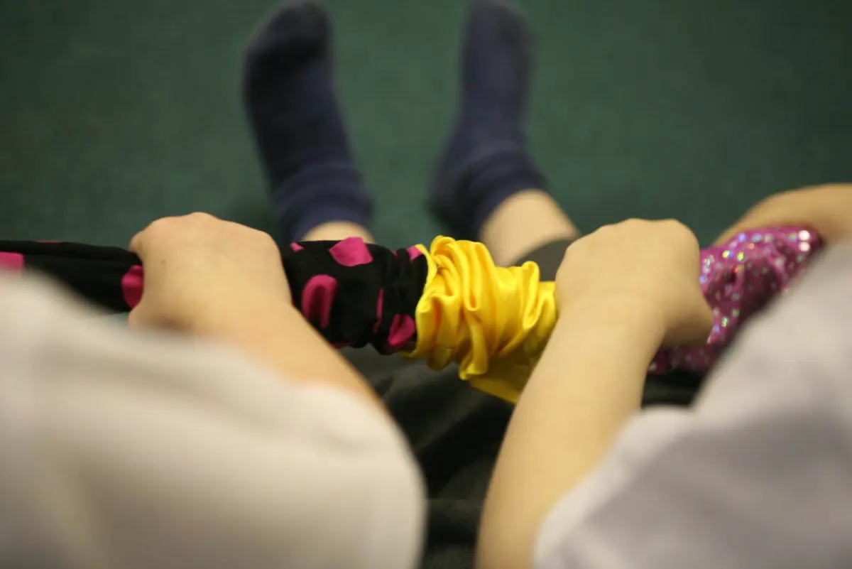 Hands holding a soft, colourful scrunchy.